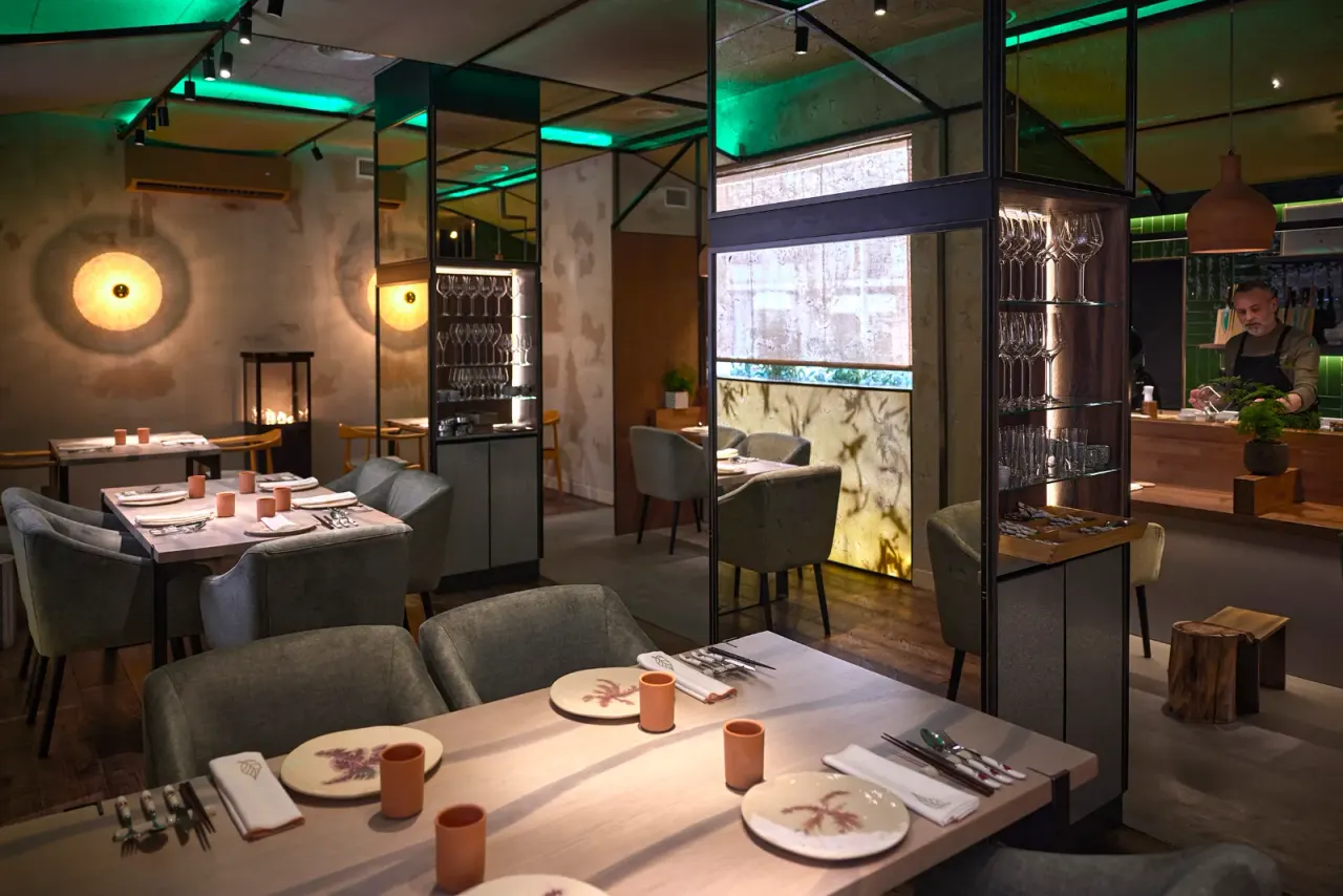 Comedor de El Invernadero con las mesas vestidas y la luz de la ventana al fondo