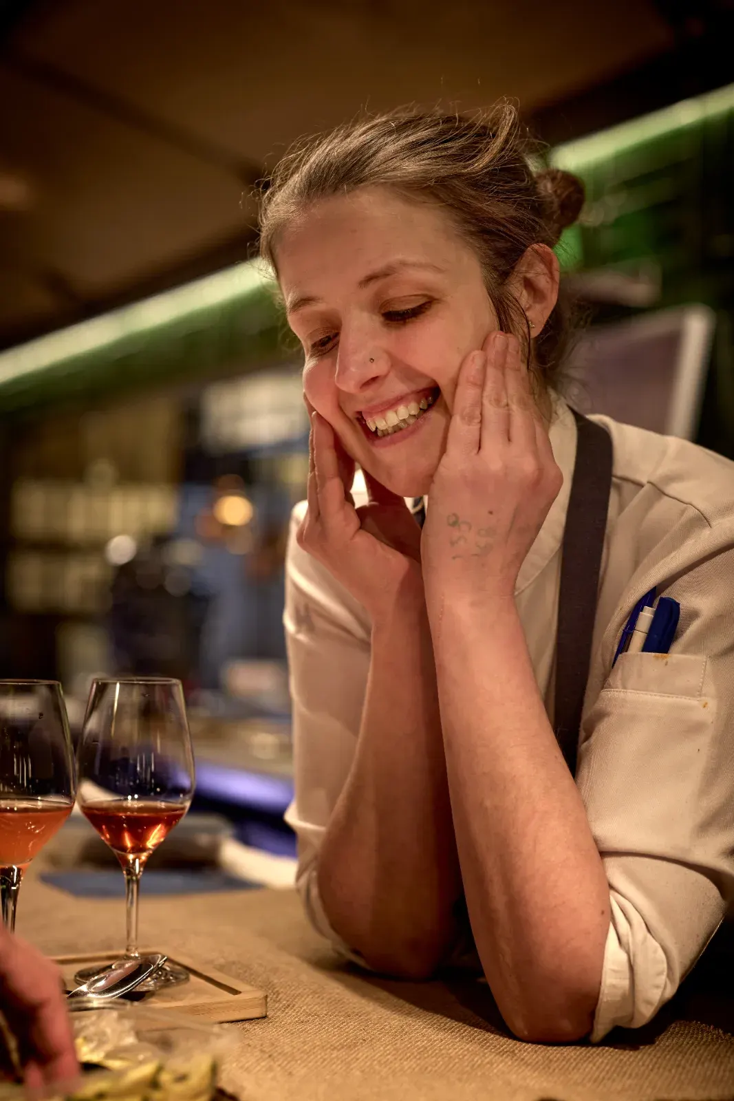 Cocinera de El Invernadero sonriendo, apoyada en la barra durante el servicio
