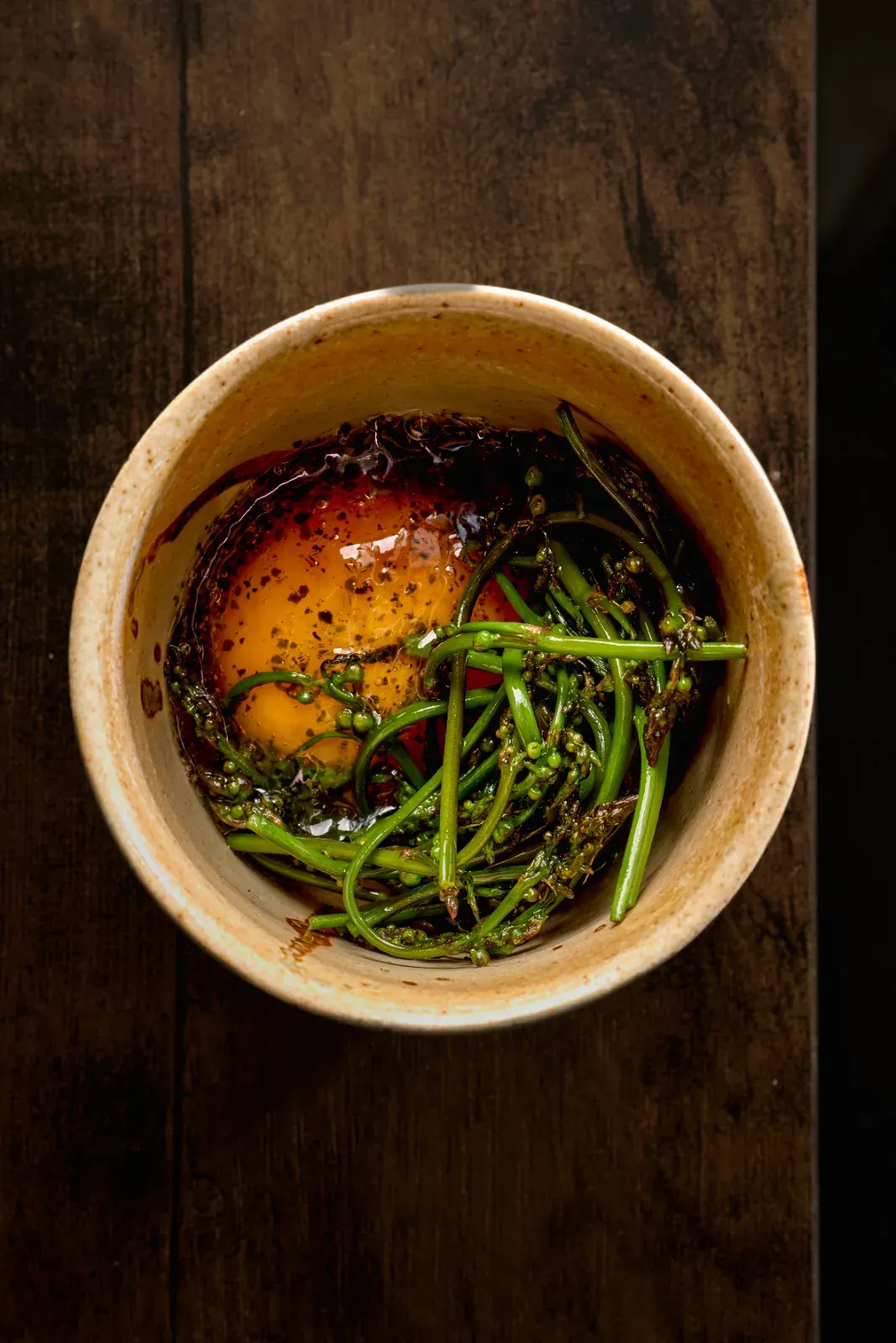 Esparraguín con yema y wakame en cuenco de barro, uno de los pases del menú degustación